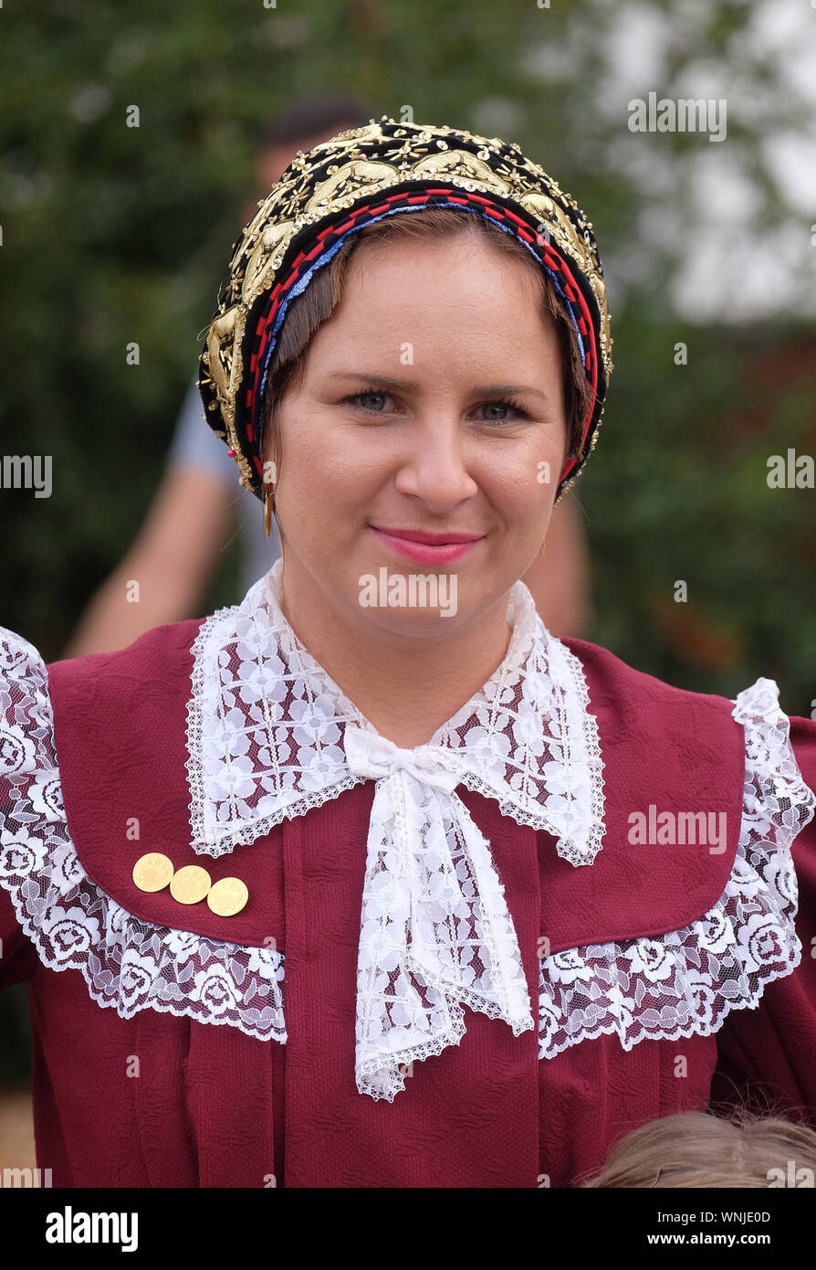 Donna vestito in costumi folcloristici andare in chiesa durante la Santa Messa il giorno del Ringraziamento in Stitar, Croazia Foto Stock