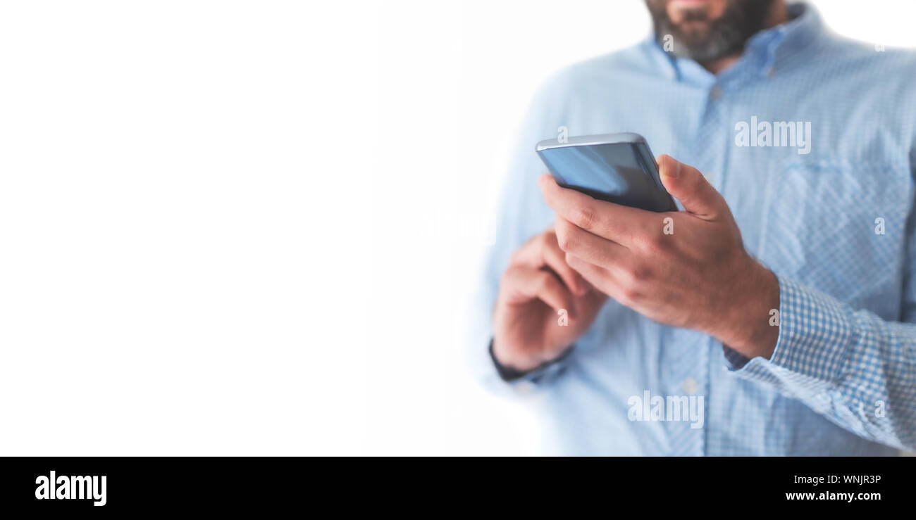 Sezione mediana dell'uomo tramite telefono cellulare o smartphone contro uno sfondo bianco Foto Stock