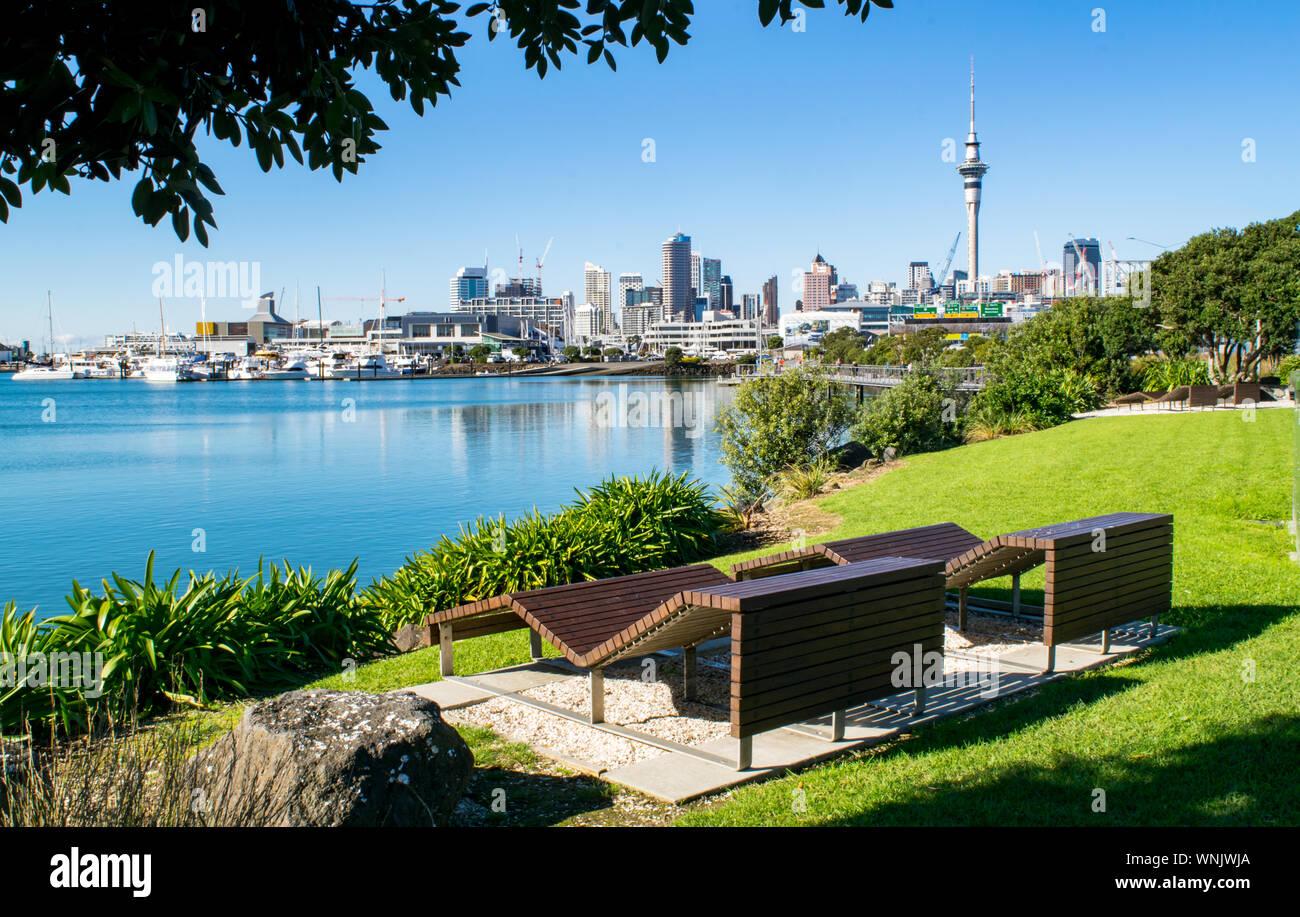 Panche di legno in Waterfront Park (vicino al porto), con una splendida vista del centro cittadino di Auckland - Auckland, Nuova Zelanda Foto Stock