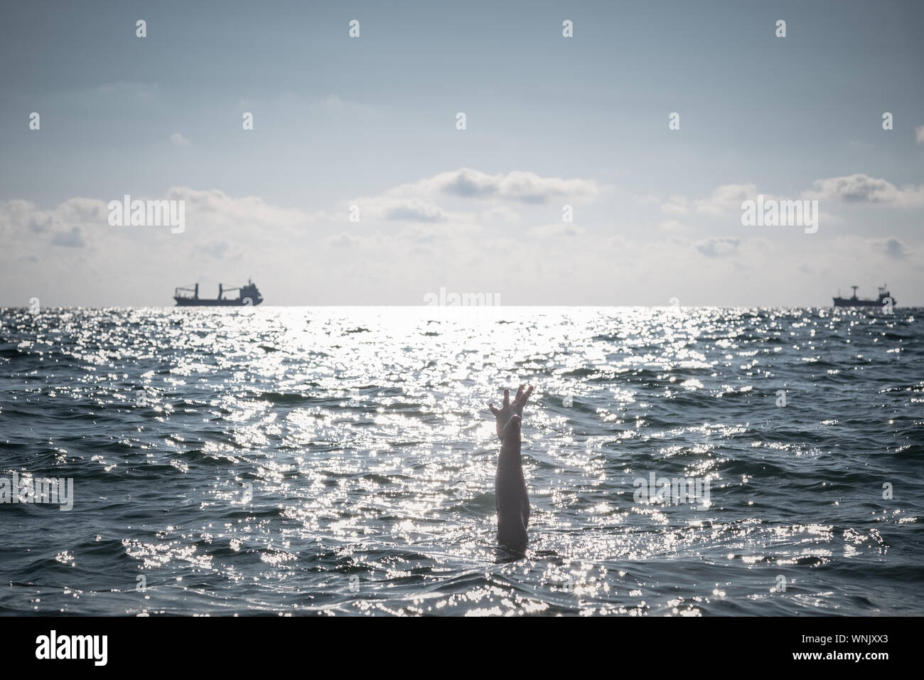 Unica mano di annegamento di uomo in mare per chiedere aiuto. sticking fuori dall'acqua Foto Stock