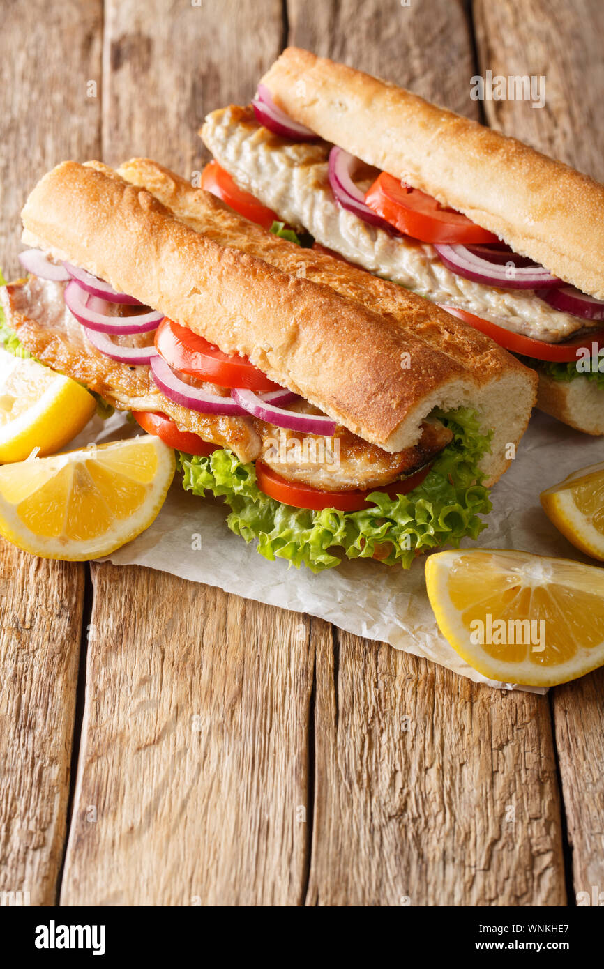 Tradizionale turca fast food panino balik Ekmek con sgombri alla griglia e verdura di close-up sul piano verticale. Foto Stock