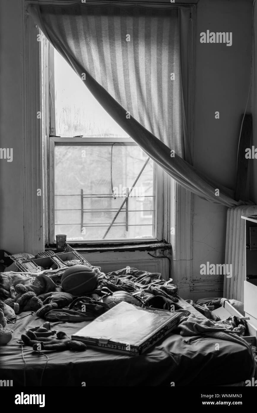 Abbandonata e molto disordinato stanza dei ragazzi in disperato bisogno di riordino, in bianco e nero Foto Stock