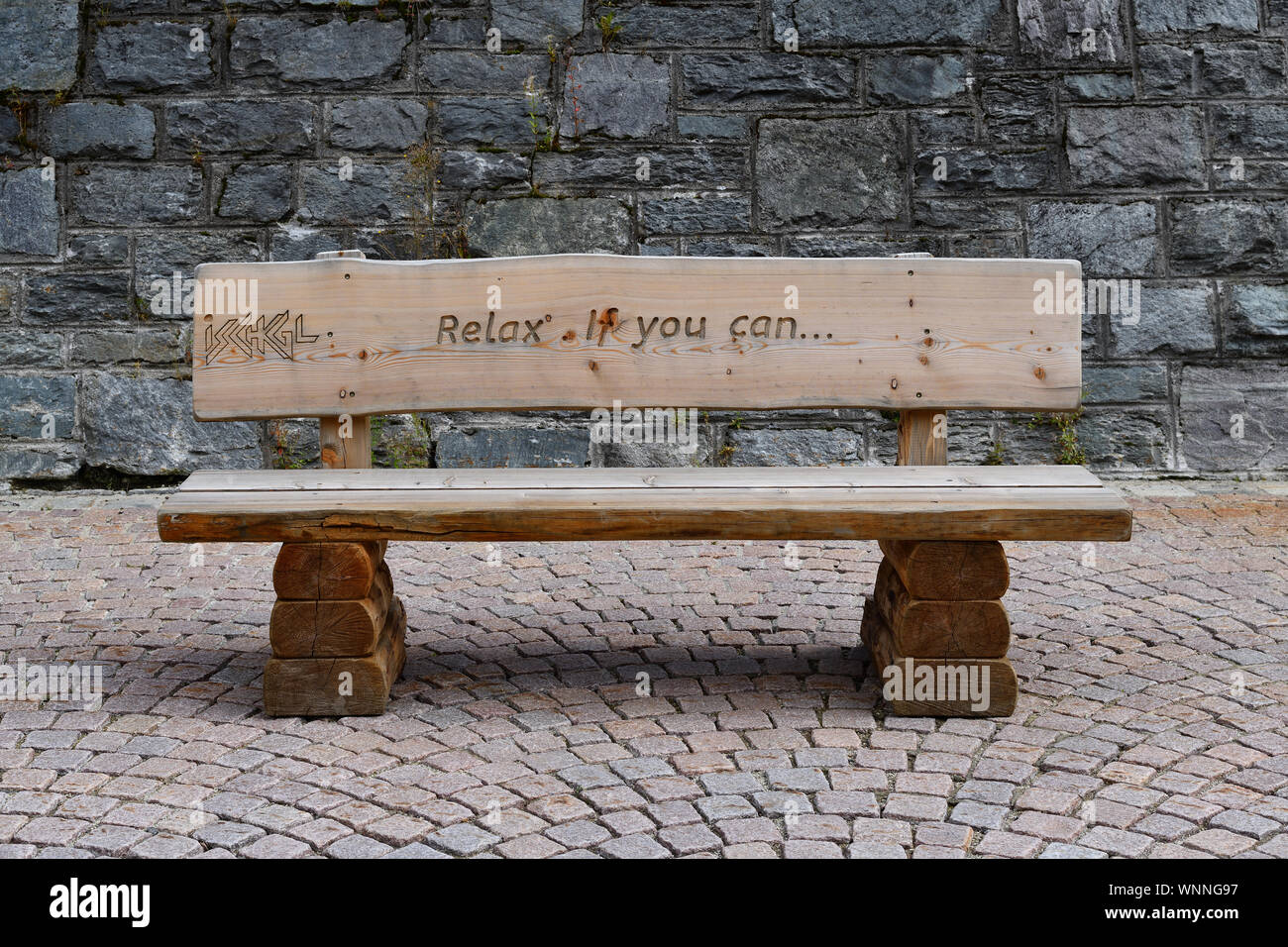 ISCHGL, Tirolo, Austria - 26 agosto 2019: panca in legno con incisa la slogan della città tirolese di Ischgl: Relax. Se è possibile. Foto Stock