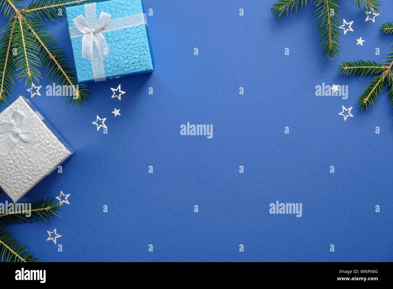 Anno nuovo o regali di Natale nastro avvolto e Abete rami su sfondo blu. Xmas, inverno, anno nuovo concetto. Sfondo di Natale, il messaggio di saluto Foto Stock