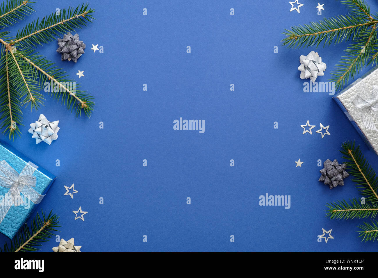 Scheda di Natale concetto con abete rami, presenta i fiocchi di neve, decorazioni su sfondo blu. Natale o Capodanno la composizione della struttura. Holiday Foto Stock
