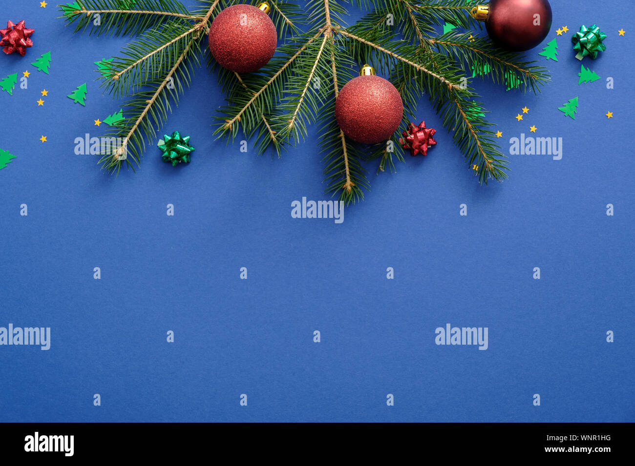 Scheda di Natale concetto con abete rami, rosso baubles, decorazioni su sfondo blu. Natale o Capodanno la composizione della struttura. Vacanza e celeb Foto Stock