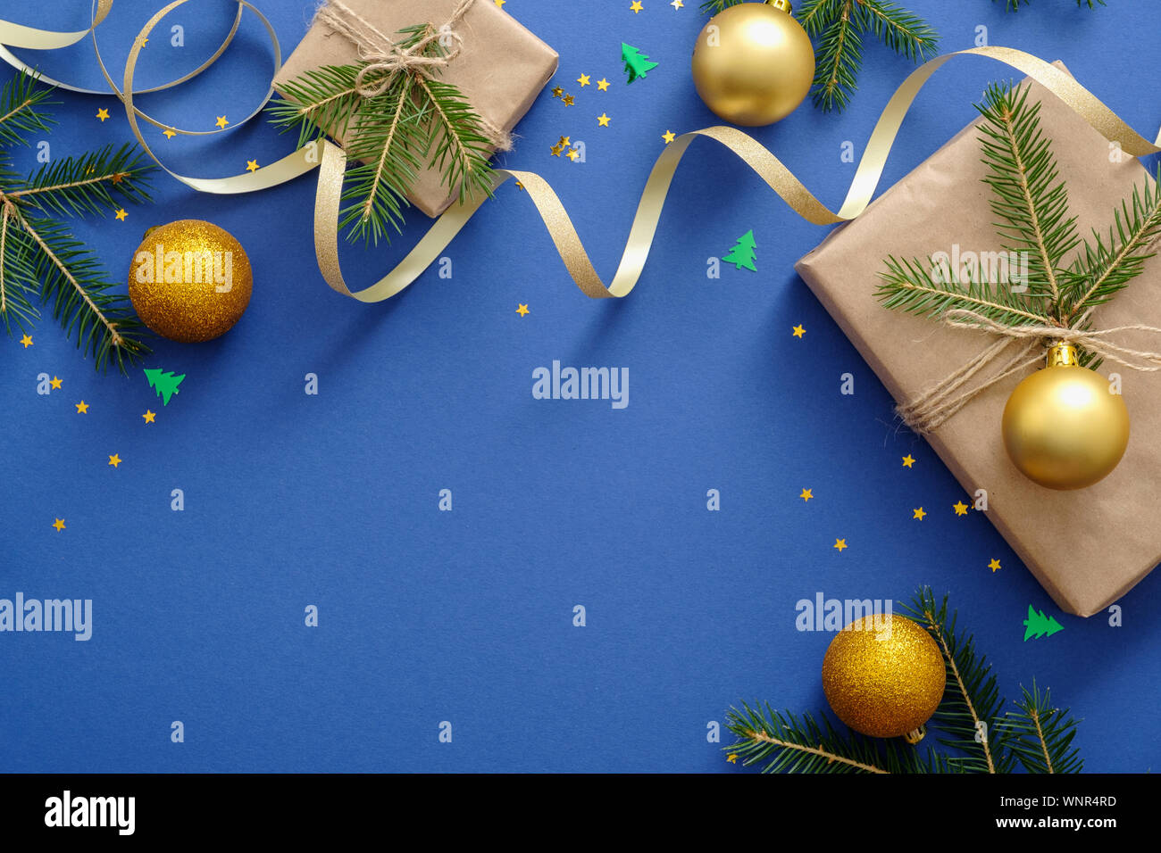 Natale o Capodanno composizione. Layout creativi con oro decorazioni di Natale, sfere, confezione regalo avvolto in carta kraft e Abete rami. Christm Foto Stock