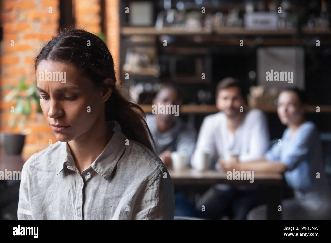 Sconvolto razza mista donna, vittima di bullismo, seduto da solo in cafe Foto Stock