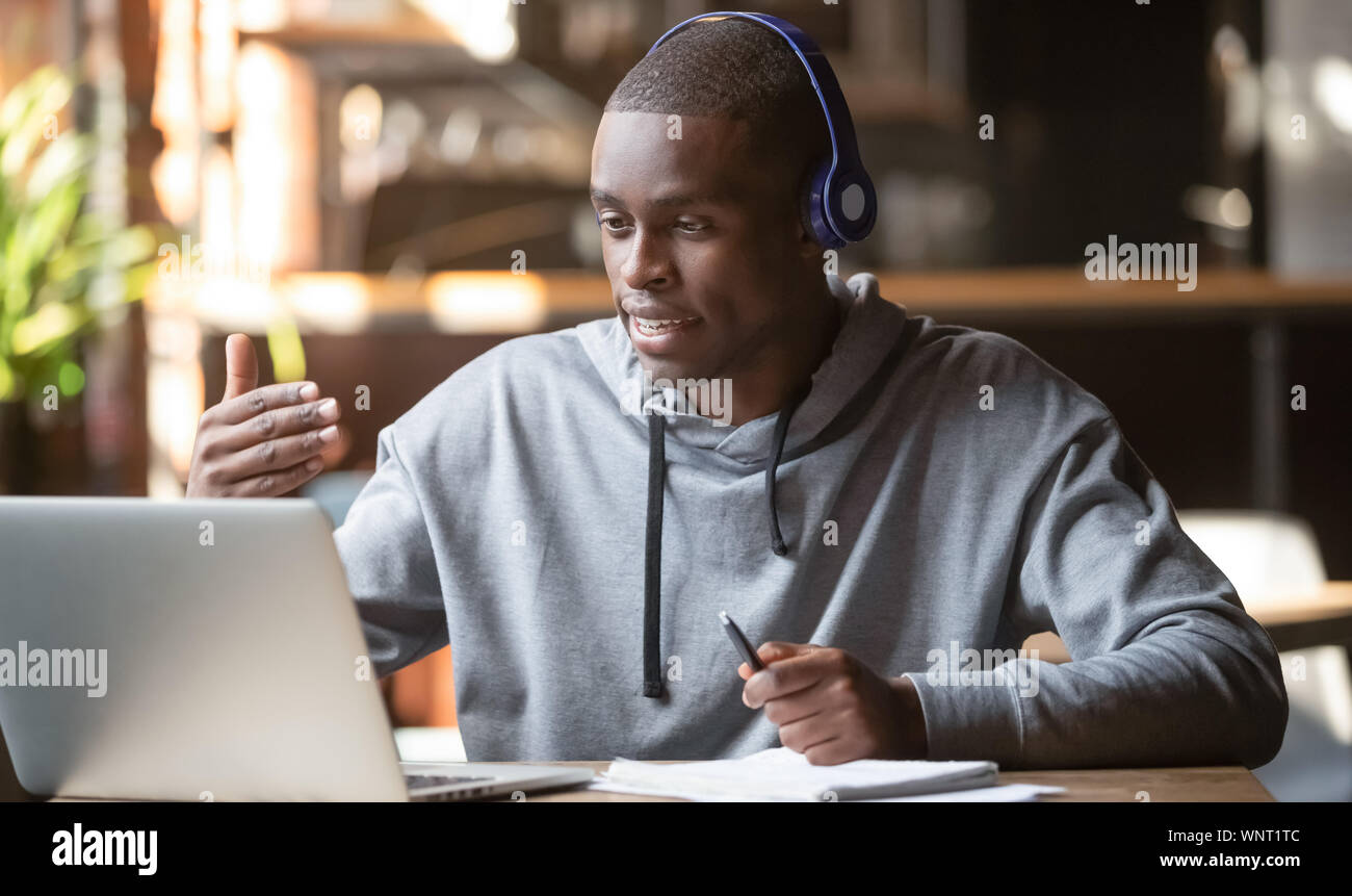 African American uomo nelle cuffie rendendo la chiamata video in cafe Foto Stock