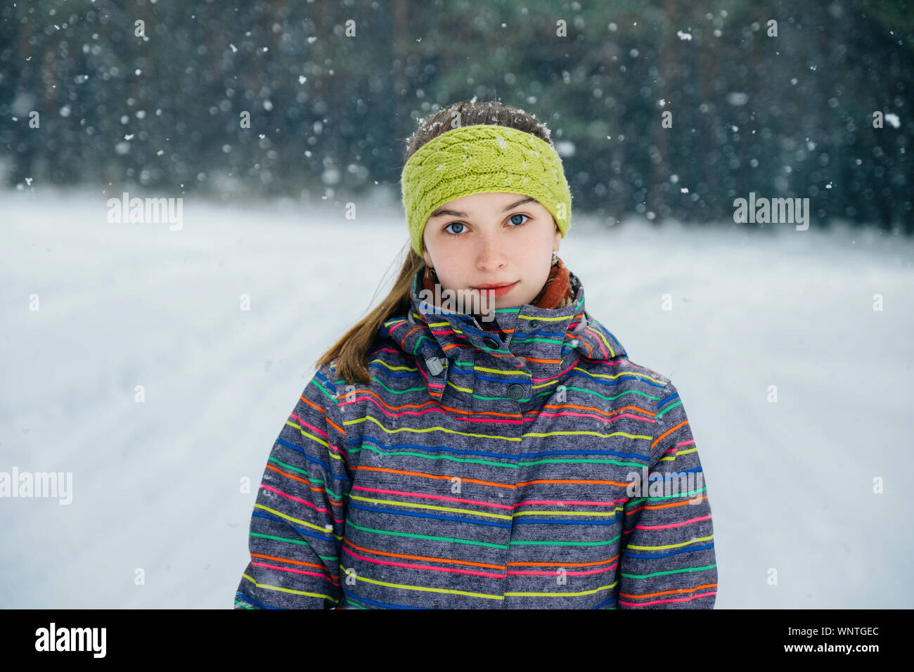 Ragazza in piedi in un bosco innevato Foto Stock