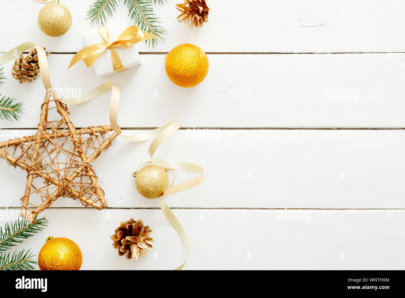 Vacanze di Natale composizione con decorazioni dorate, palline, stella, doni, nastro, Abete rami, pigne di legno su sfondo bianco. Piatto, laici Foto Stock