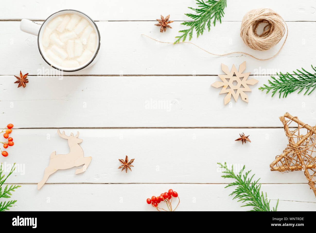 Composizione di natale. Cornice in abete rami, decorazioni di Natale, tazza di cioccolata calda con marshmallow, bacca rossa di legno su sfondo bianco. Foto Stock