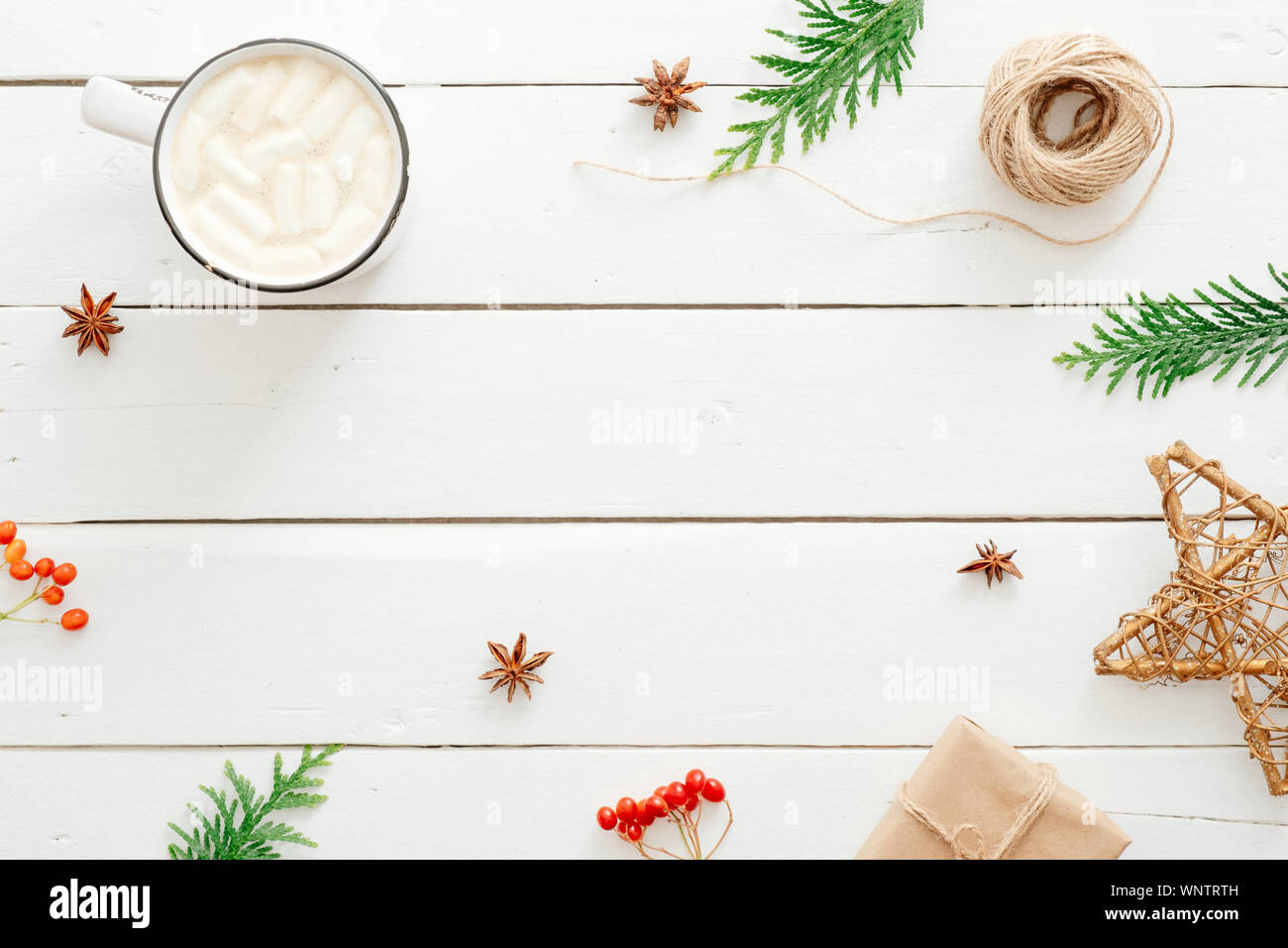 Composizione di natale. Cioccolata calda con marshmallows cup, Abete rami, confezione regalo natale decorazione su legno rustico sfondo bianco. Minim Foto Stock