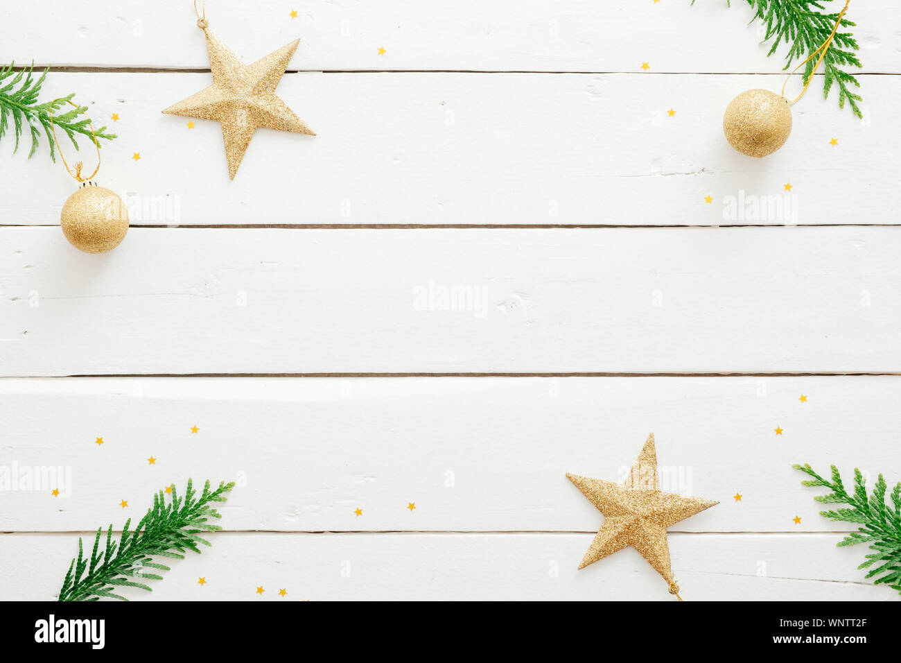 Natale composizione minima. Telaio di Natale fatto di Abete rami, decorazioni dorate, ornamenti su bianco scrivania in legno. Natale, Capodanno, win Foto Stock