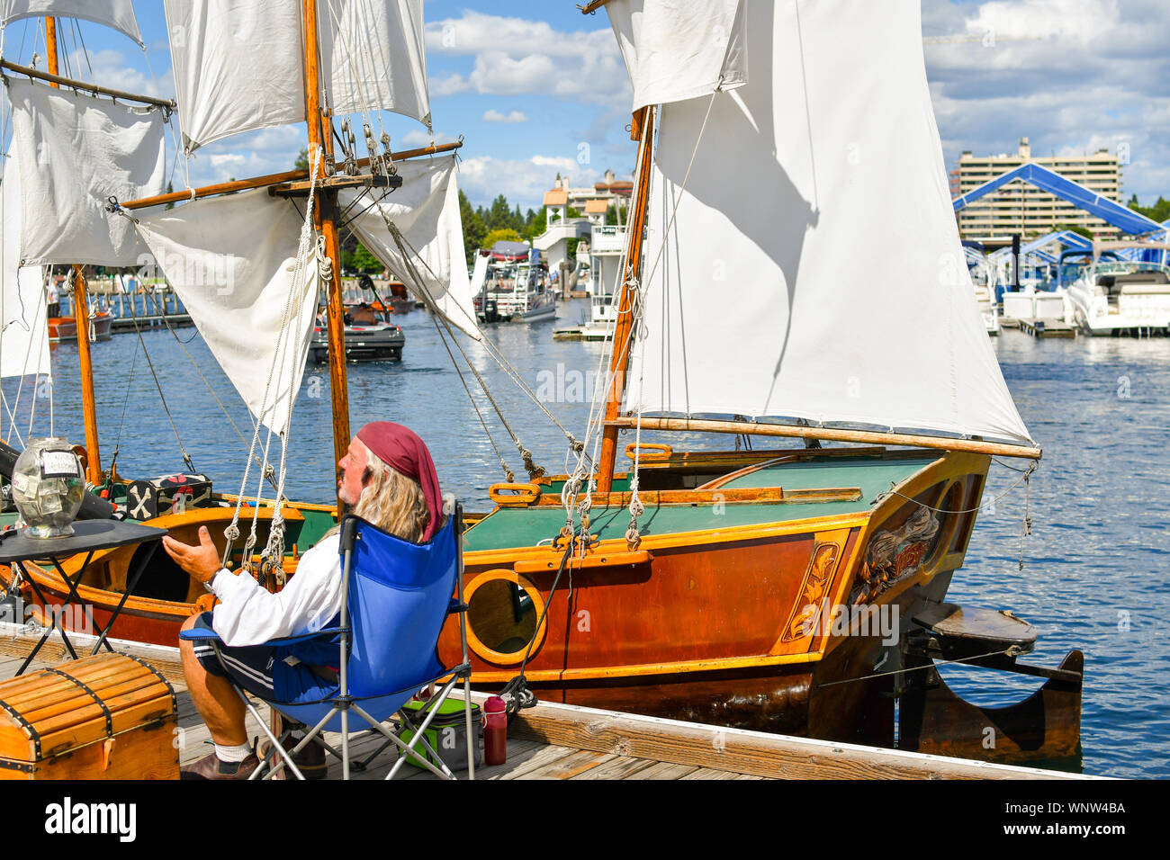 Un proprietario di imbarcazione vestito come un pirata vicino alla sua replica in miniatura nave sulla base di Columbus navi ancorate alla marina per le barche in legno show. Foto Stock
