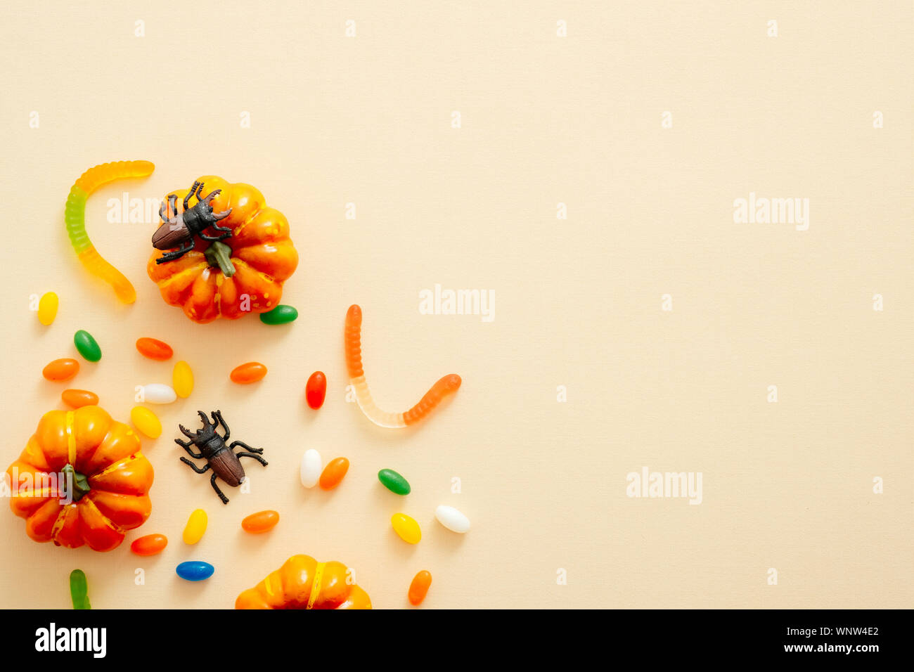 Moderna sullo sfondo di Halloween con zucche, candy, decorazioni con copia spazio per il testo. Isolato su pastello sfondo beige. Appartamento laico, vista dall'alto, overh Foto Stock