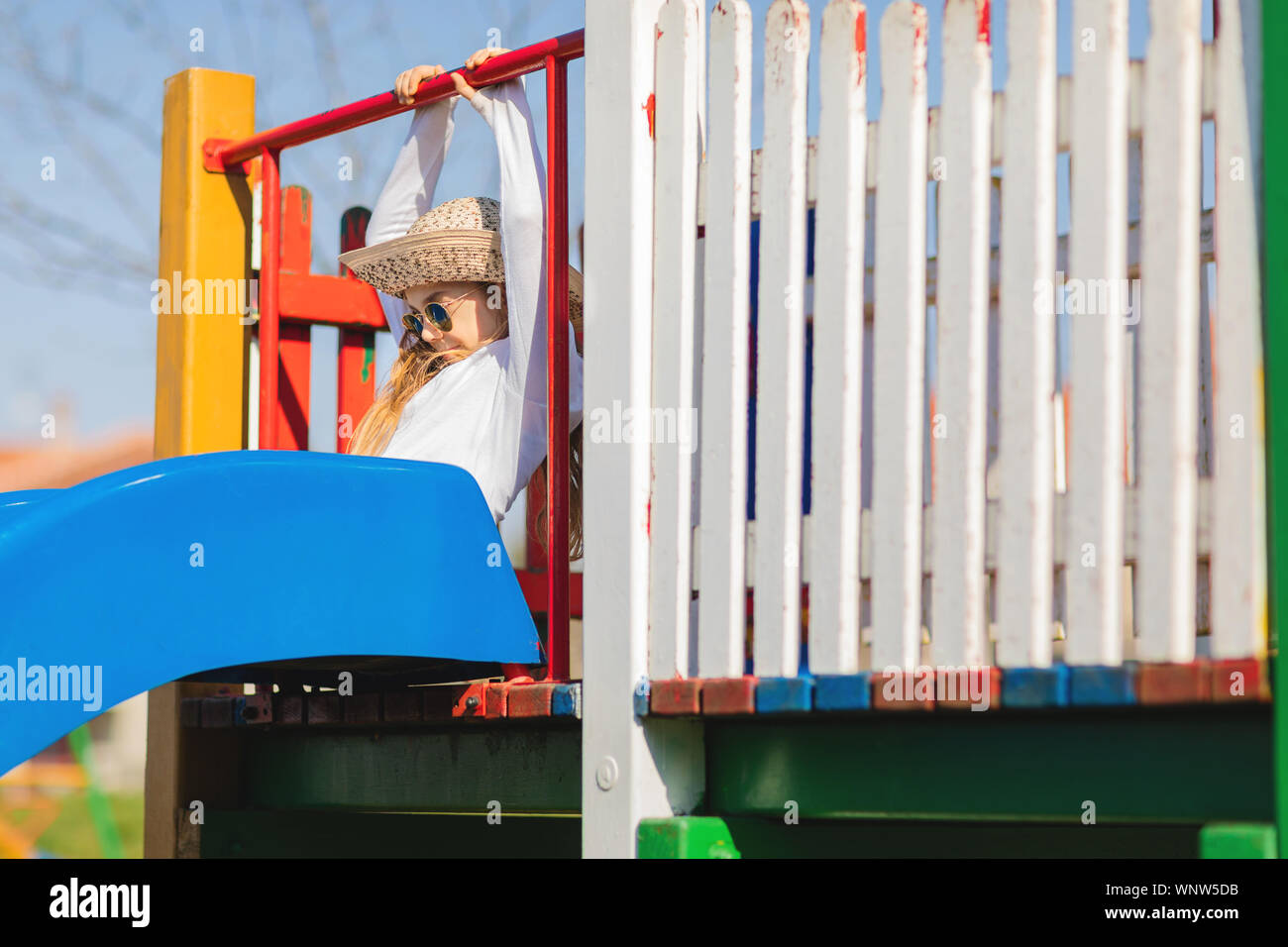 Giovane ragazza hipster con occhiali da sole e cappello sul parco giochi Foto Stock