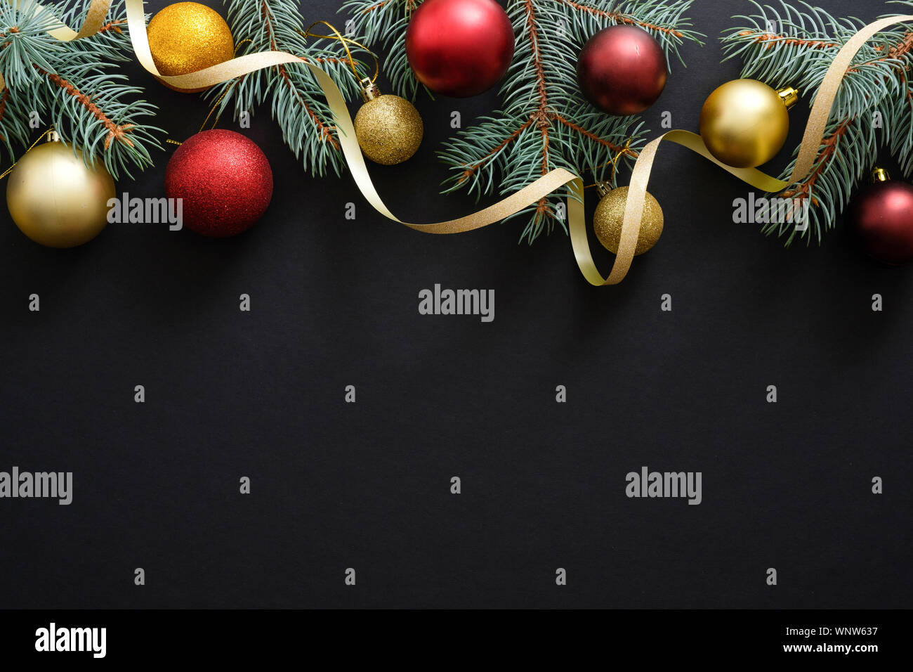 Nero lo sfondo di Natale con oro rosso e decorazioni, baubles, Abete rami. Vacanze di Natale celebrazione, inverno, Anno Nuovo concetto. Chris Foto Stock