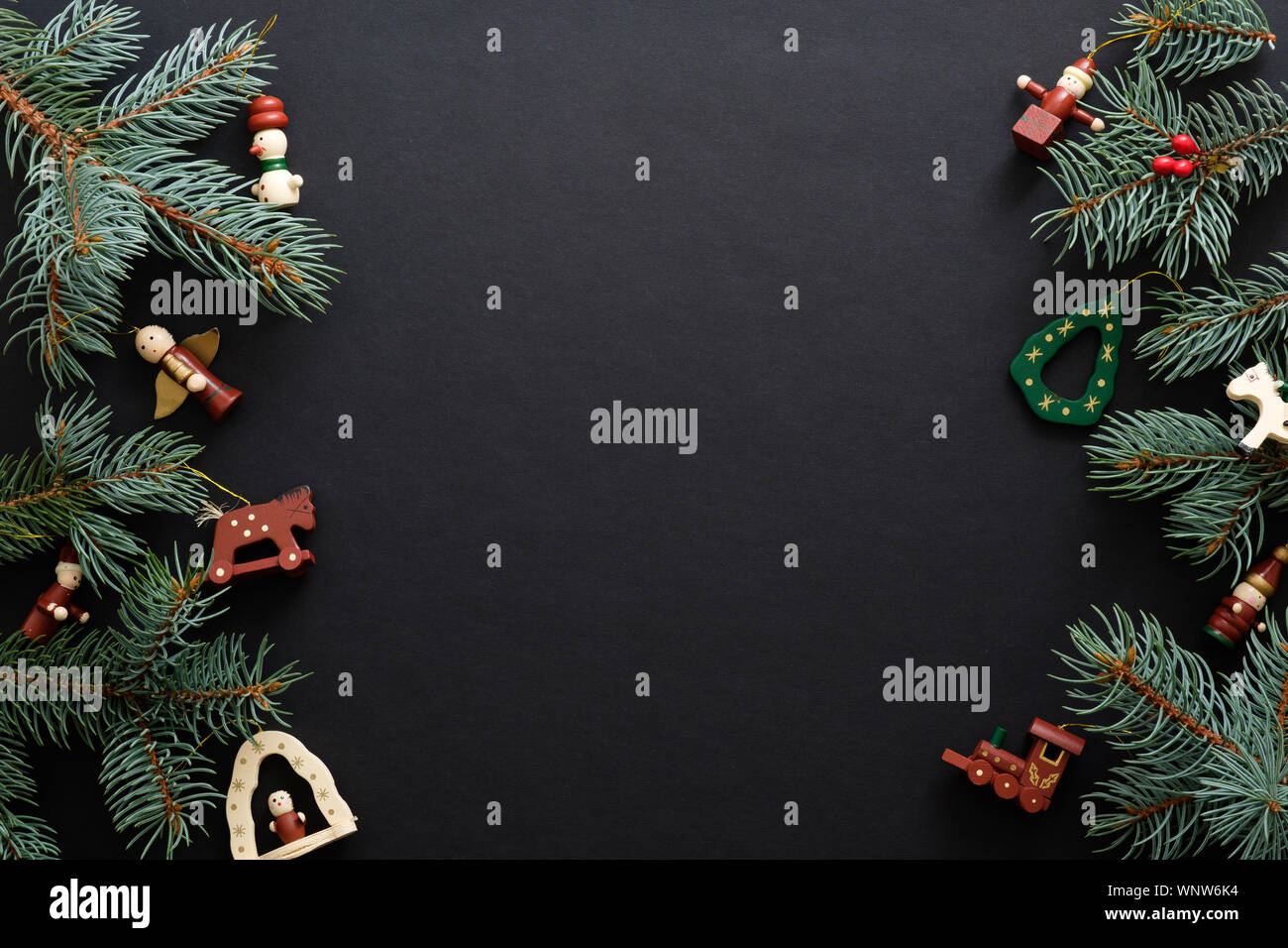 Nero lo sfondo di Natale fatti a mano con decorazioni in legno di abete e rami di alberi. Vacanze di Natale celebrazione, inverno, Anno Nuovo concetto. Natale Foto Stock