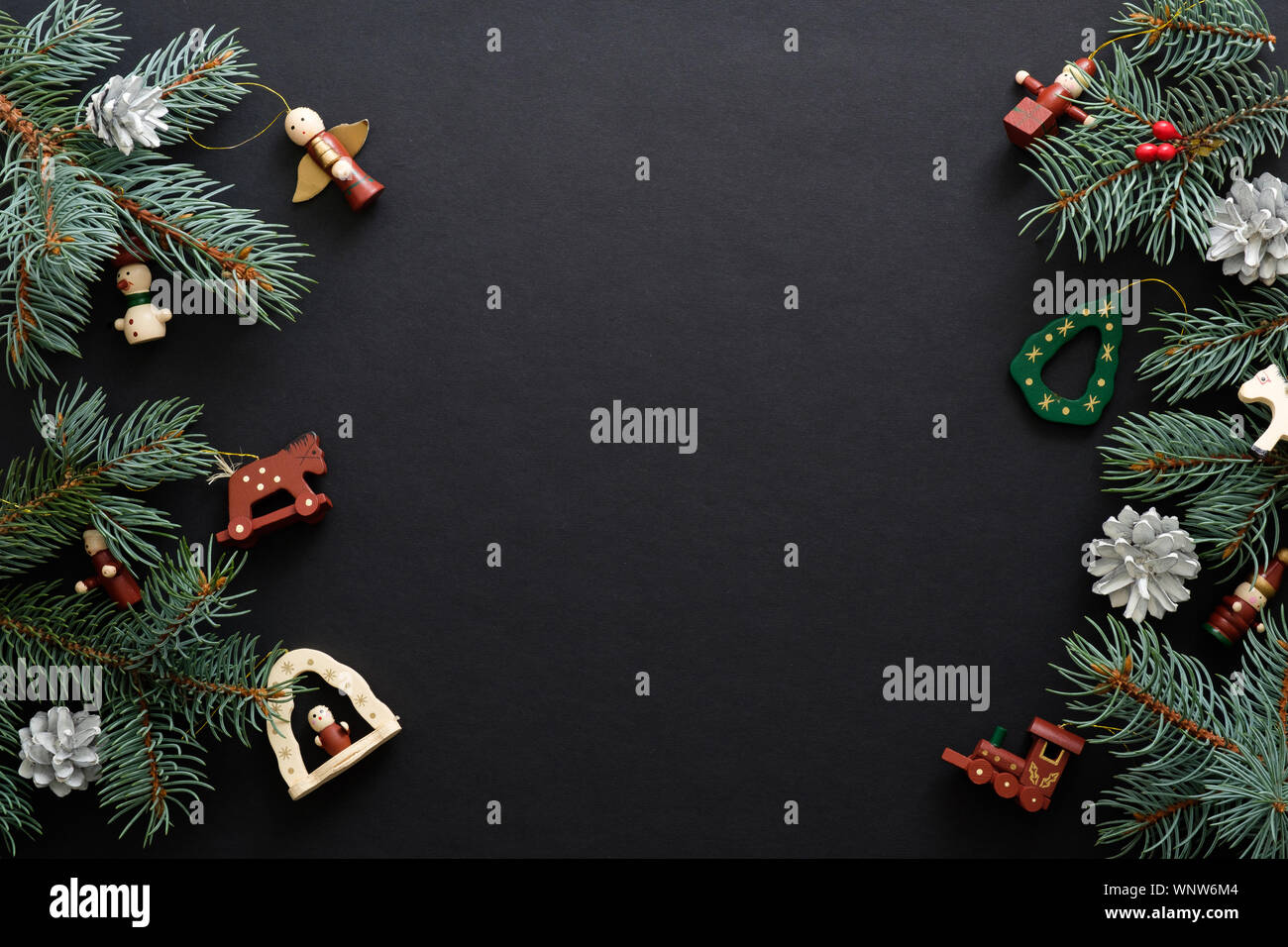 Nero lo sfondo di Natale fatti a mano con decorazioni in legno di abete e rami di alberi. Vacanze di Natale celebrazione, inverno, Anno Nuovo concetto. Natale Foto Stock