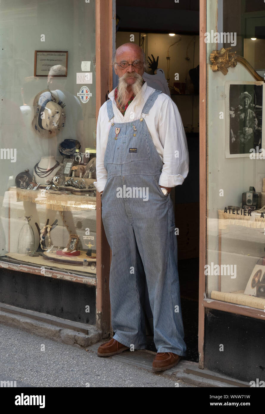 Uomo vecchio con una lunga barba bianca e i baffi in tute le protezioni anteriore dello store. Foto Stock