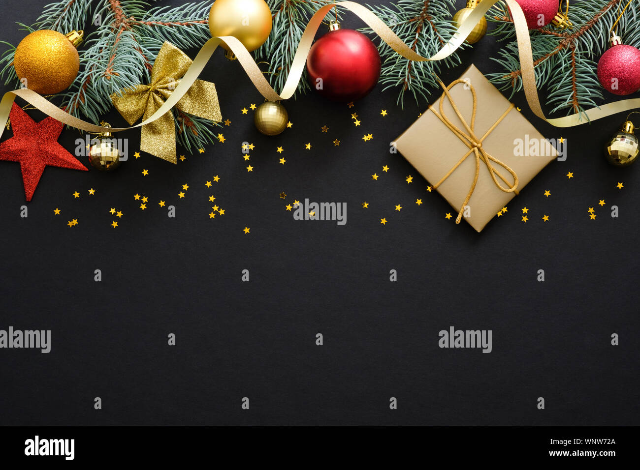 Natale sfondo nero con abete rami, decorazioni, rosso e golden baubles. confezione regalo, coriandoli. Natale, vacanza invernale, Nuovo Anno concep Foto Stock