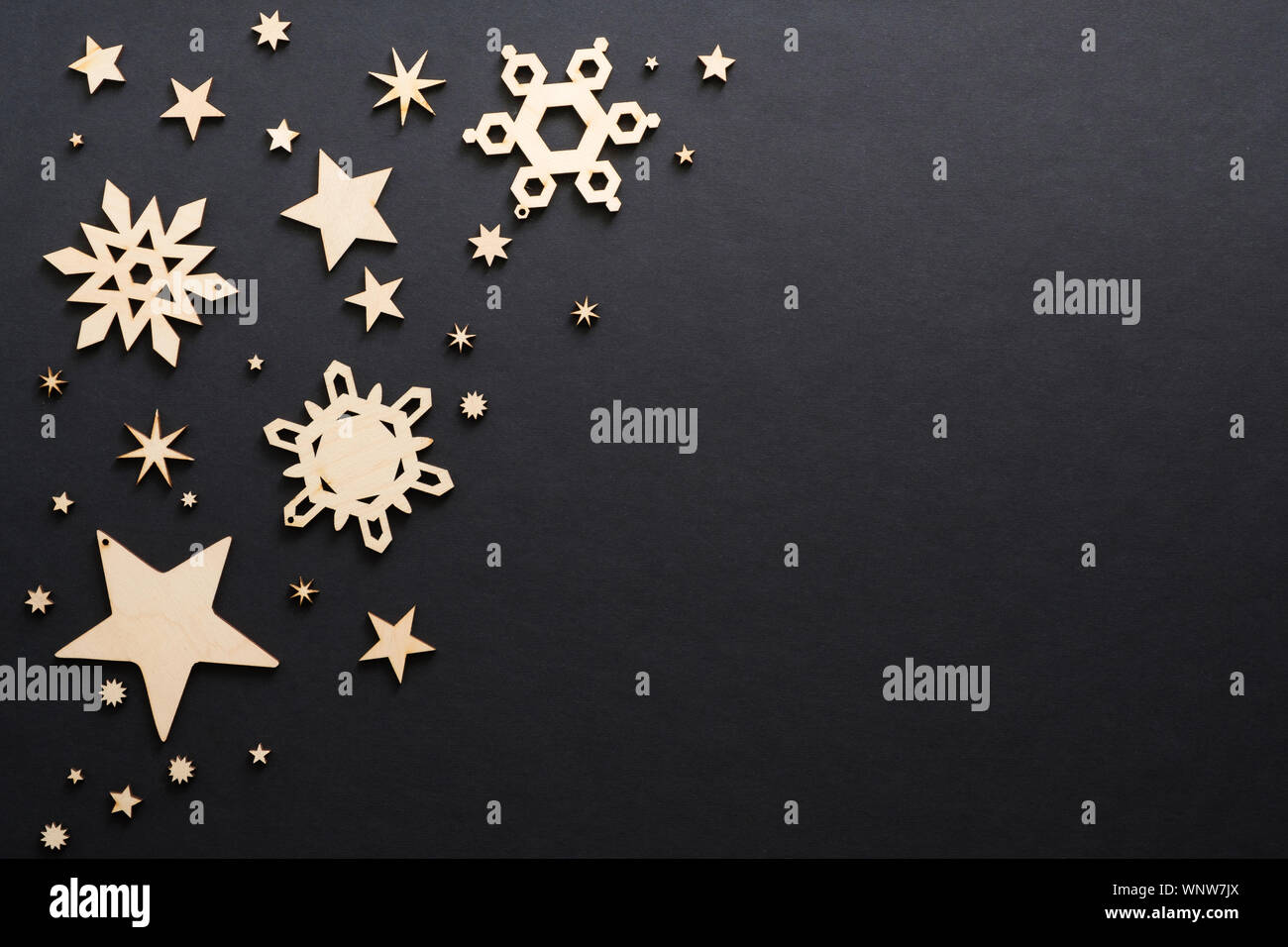 In legno realizzati a mano decorazioni di Natale sul nero scuro dello sfondo. Il Natale di fiocchi di neve e stelle con copia spazio. Appartamento laico, vista dall'alto. Vacanze invernali, C Foto Stock