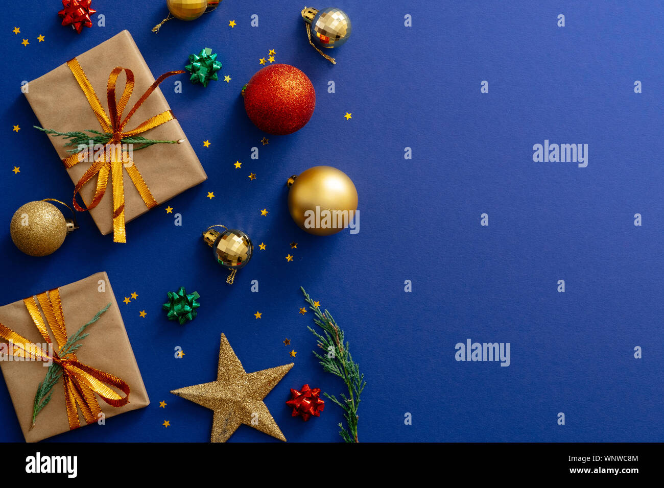 Vacanze di Natale composizione. Le decorazioni di Natale, regali, baubles su sfondo blu scuro con copia spazio. Banner mockup, cartolina. Piatto, laici per Foto Stock