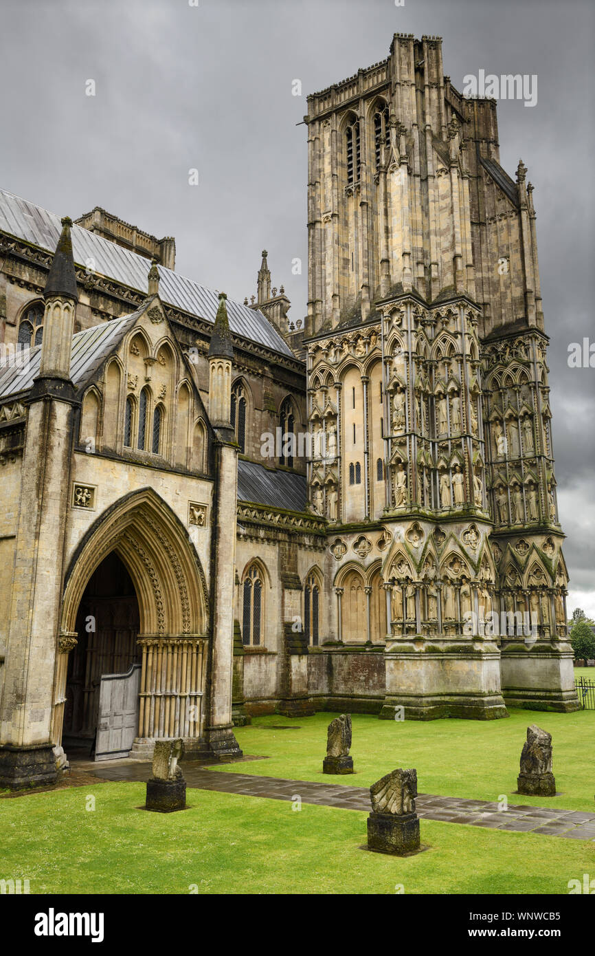 Il portico settentrionale entrata principale e il nord-ovest della torre della Cattedrale di Wells sotto la pioggia nuvole pozzetti Inghilterra Foto Stock