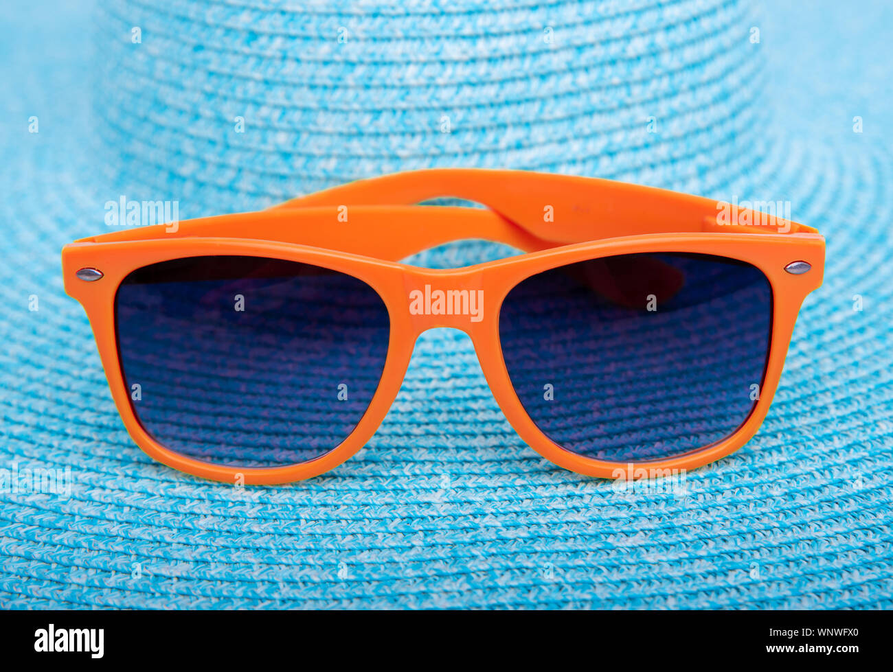 Arancione occhiali da sole estivo su un blu. Foto Stock