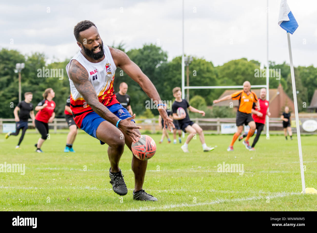 Amatori rugby touch player (Fijian maschio, 40-50 y) cade la sfera come egli raggiunge verso il basso con la sfera al cliente una prova Foto Stock