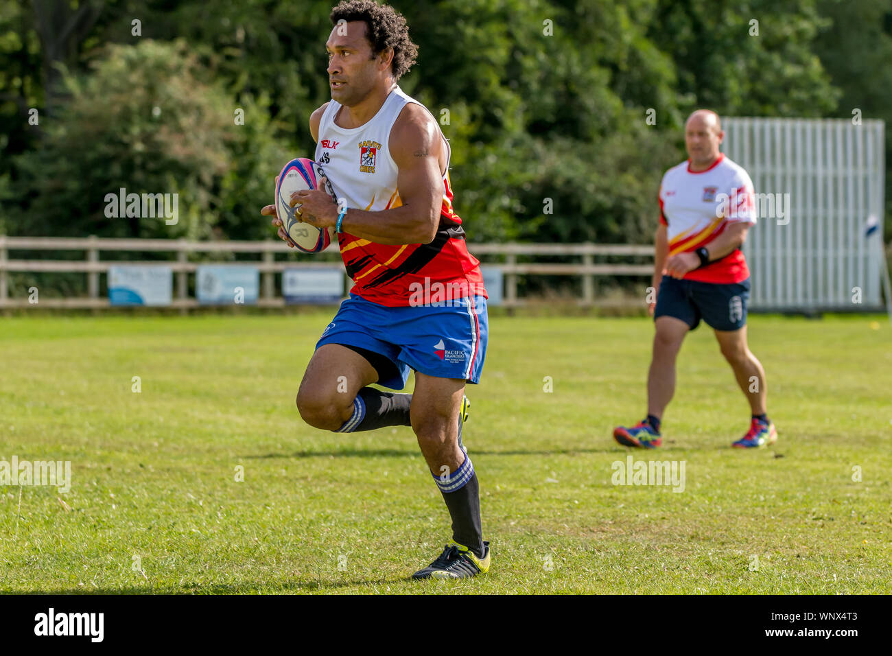 Amatori rugby touch player (fijian maschio, 30-40 y) in esecuzione con la palla da rugby in mani Foto Stock