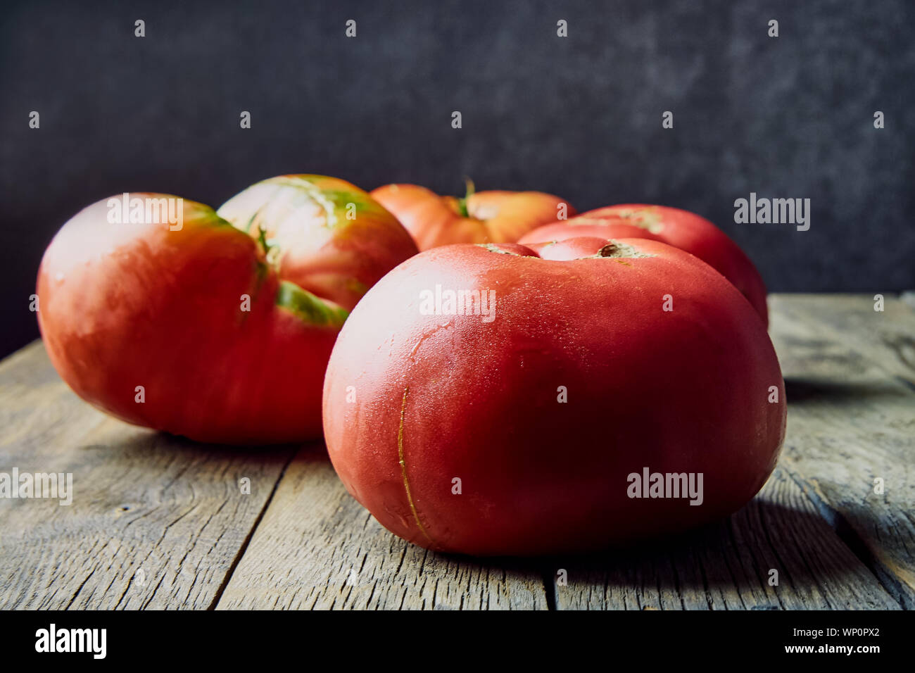 Colorate, fresche, grandi homegrown pomodori su un vecchio tavolo di legno. La raccolta . Foto Stock