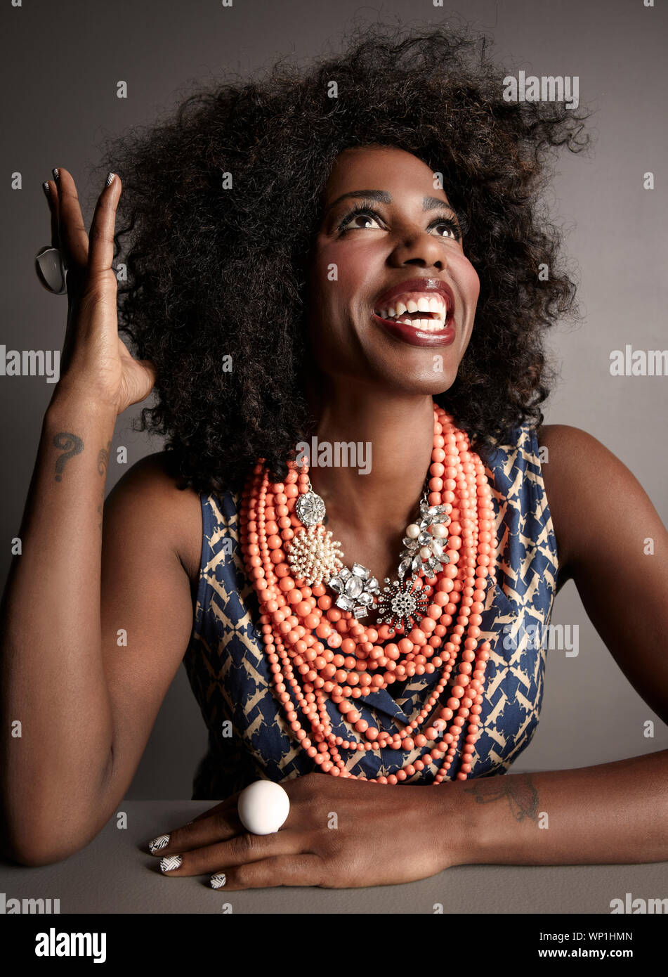 Sorridente americano africano donna adulta ritratto in studio su grigio backgroun Foto Stock