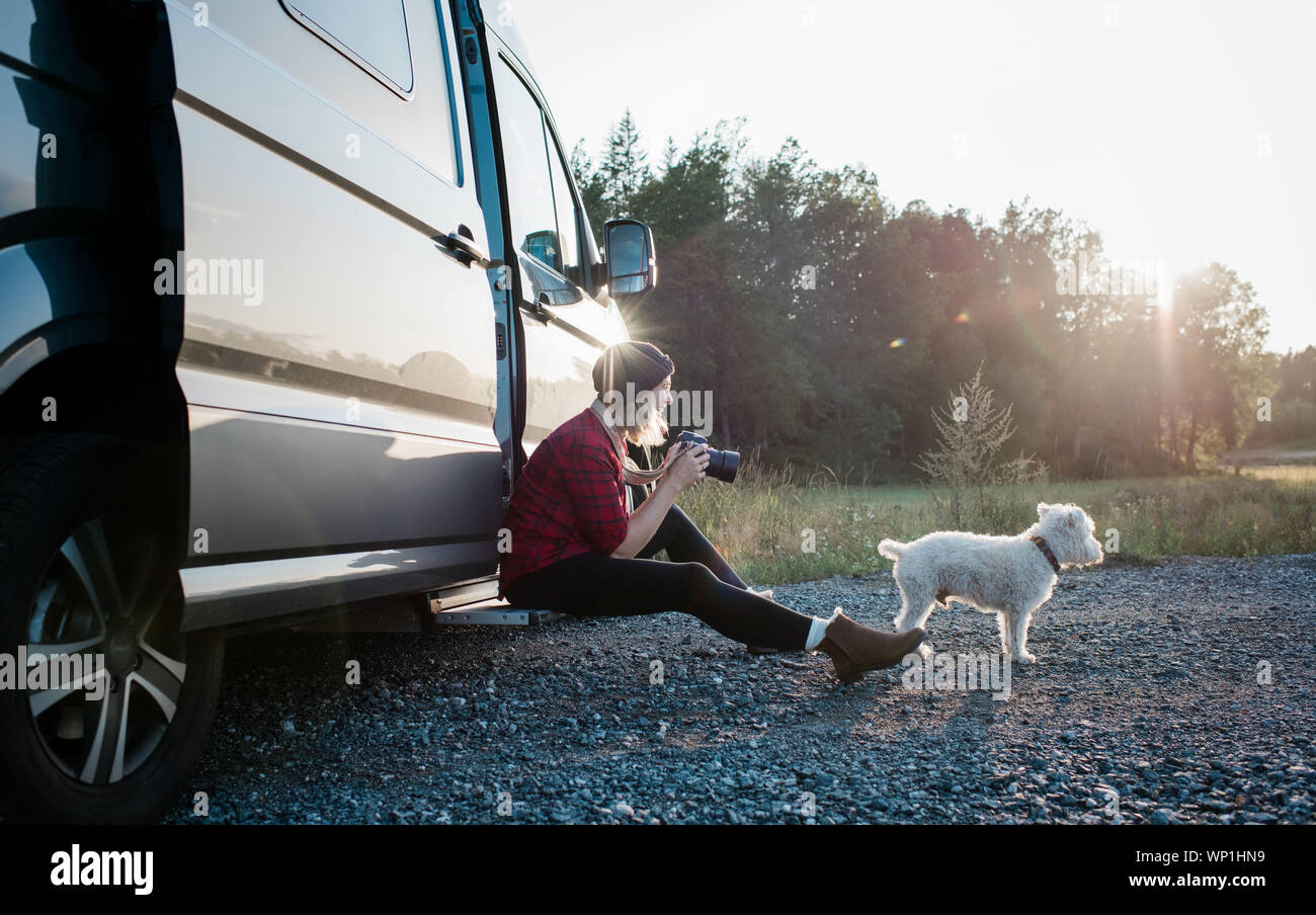Donna che parla di una foto del suo cane mentre il campeggio in estate Foto Stock