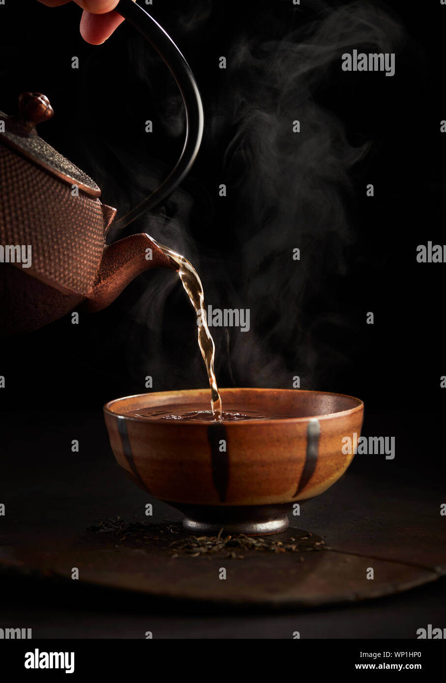 Il tè caldo versando in coppa Foto Stock