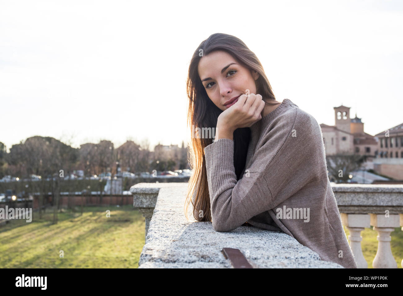 Ritratto di donna in appoggio la testa sulla sua mano mentre appoggiata su pietra Foto Stock