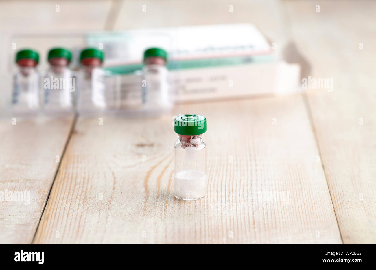 Vetro trasparente bottiglia di medicina iniettabili. Close-up, luce sullo sfondo di legno Foto Stock