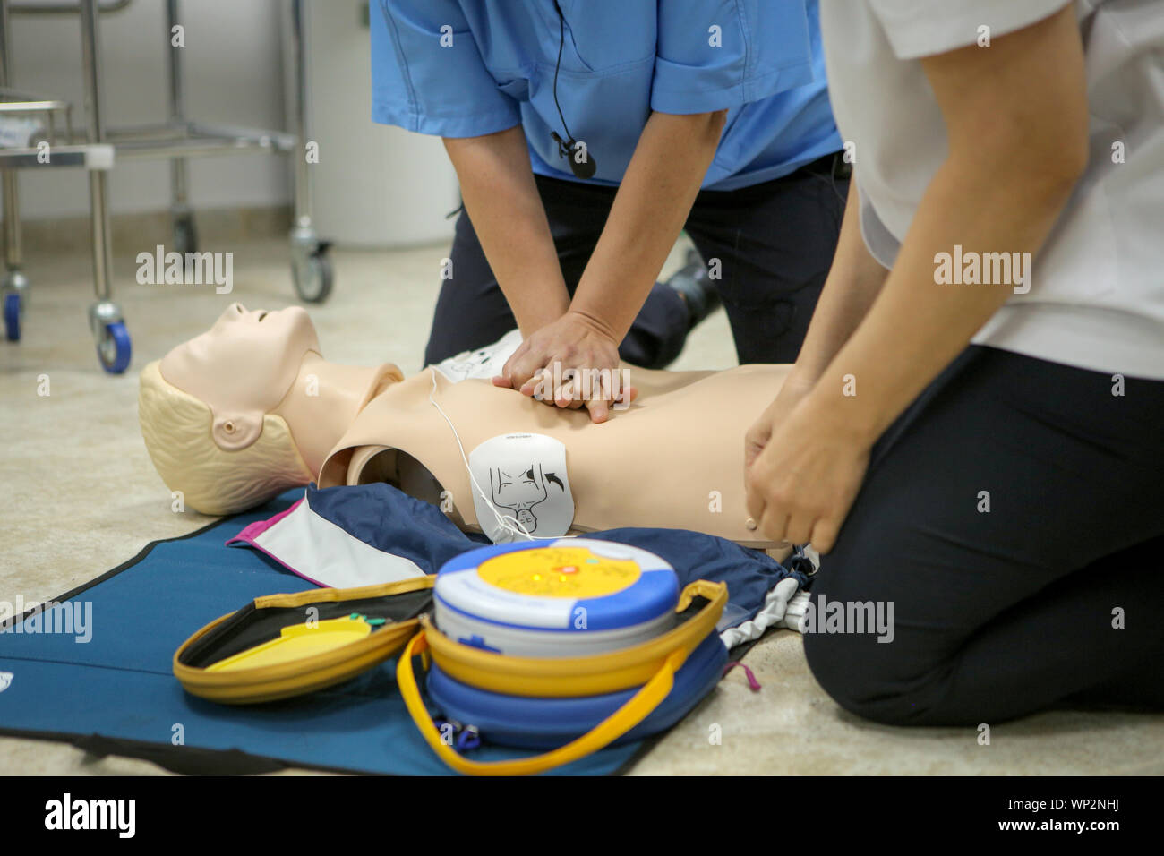 Donna medic dimostra CPR metodi su un manichino di plastica Foto Stock