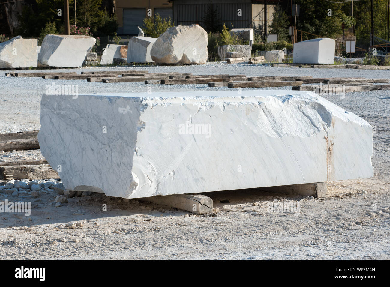 Rettangolare grande blocco di taglio del marmo bianco di Carrara nel  piazzale della miniera o cava in appoggio su travi in legno in Toscana,  Italia Foto stock - Alamy