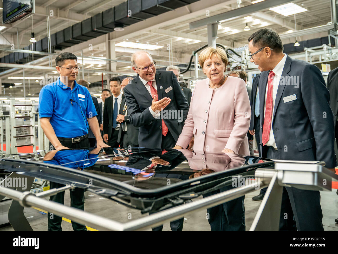 Wuhan, Cina. 07Th Sep, 2019. Il cancelliere tedesco Angela Merkel (CDU) e CEO Webasto Holger Engelmann (secondo da sinistra) prendere uno sguardo alla produzione di tettucci apribili durante un tour di un nuovo impianto del fornitore tedesco dell'industria automobilistica Webasto. Merkel è su una due giorni di visita alla Repubblica popolare cinese. Credito: Michael Kappeler/dpa/Alamy Live News Foto Stock