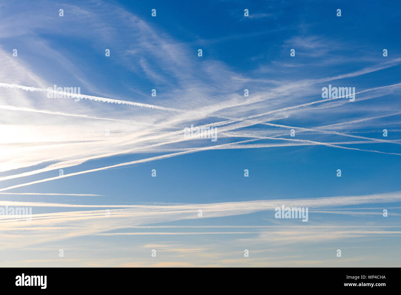 Numero straordinario di aeromobili contrails sotto fresca e chiara windless condizioni su un Marzo giornata di primavera in Spagna. Questi riducono la luce del sole e di un Foto Stock