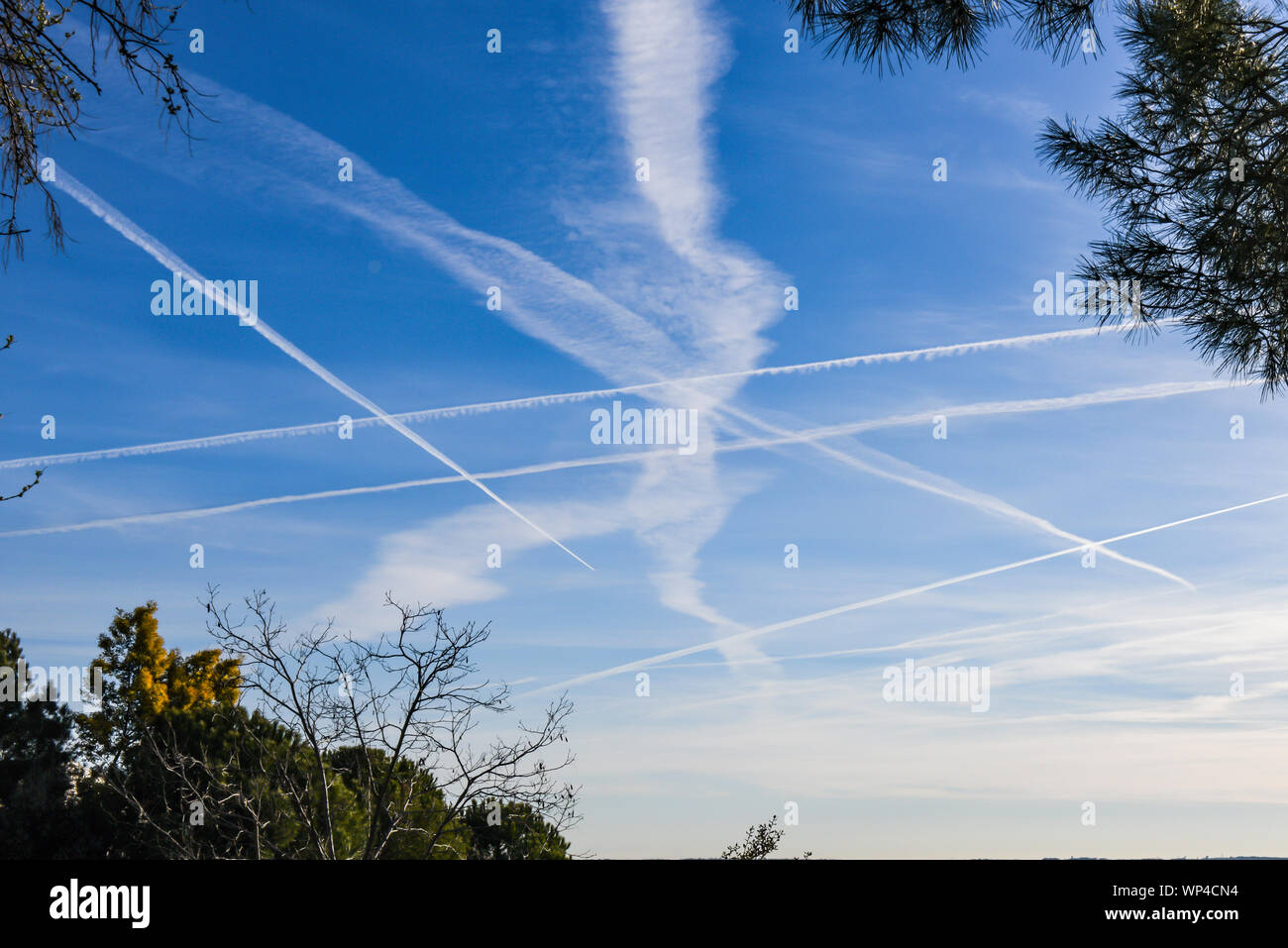 Numero straordinario di aeromobili contrails sotto fresca e chiara windless condizioni su un Marzo giornata di primavera in Spagna. Questi riducono la luce del sole e di un Foto Stock