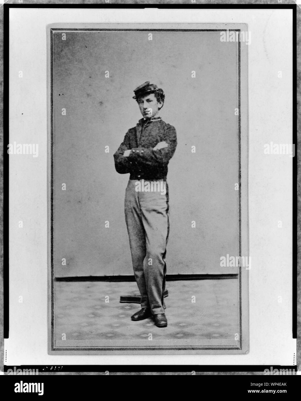 John Longnecker, ritratto a figura intera, in piedi con le braccia incrociate su petto rivolto verso sinistra Foto Stock