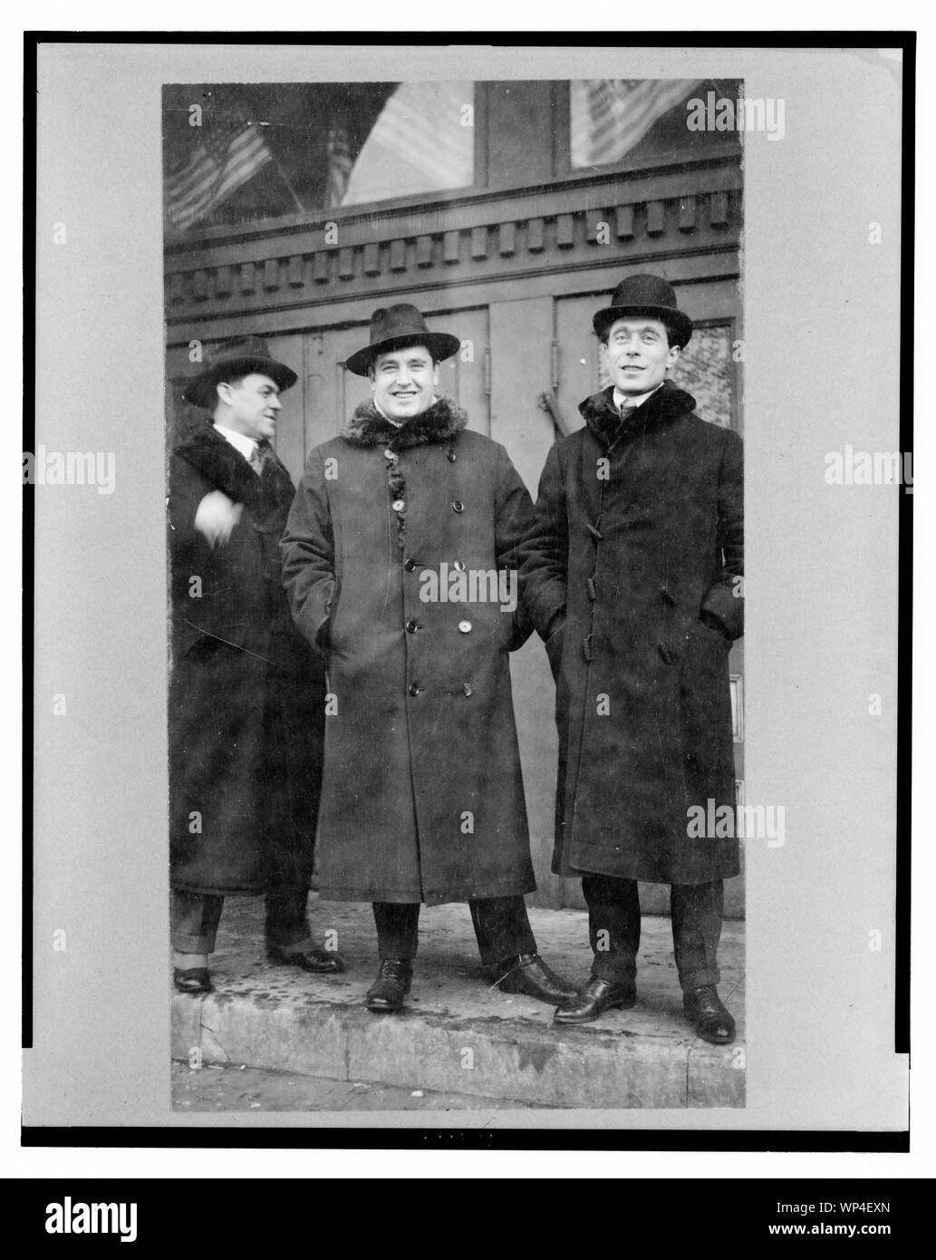 John McCormack, irlandese-americano nato il tenore di intera lunghezza verticale, rivolto verso la parte anteriore, in piedi con due uomini sui gradini fuori dall'edificio Foto Stock