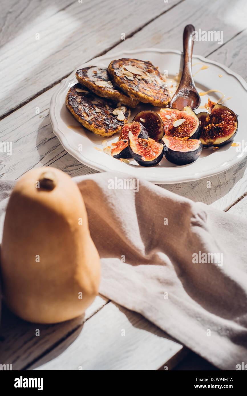 Frittelle di zucca con figure bianche su un tavolo di legno. Fotografia di cibo, alimentare il concetto di blogging Foto Stock