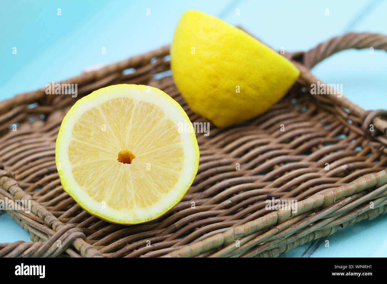Due metà di ripe limone sul vassoio di vimini Foto Stock