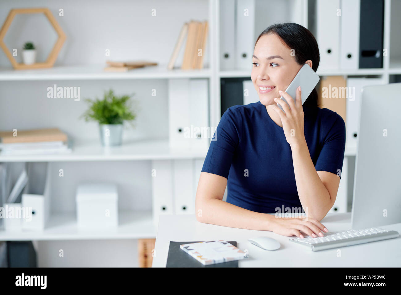 Giovani manager in elegante blu scuro abito clienti consulenza sul telefono Foto Stock
