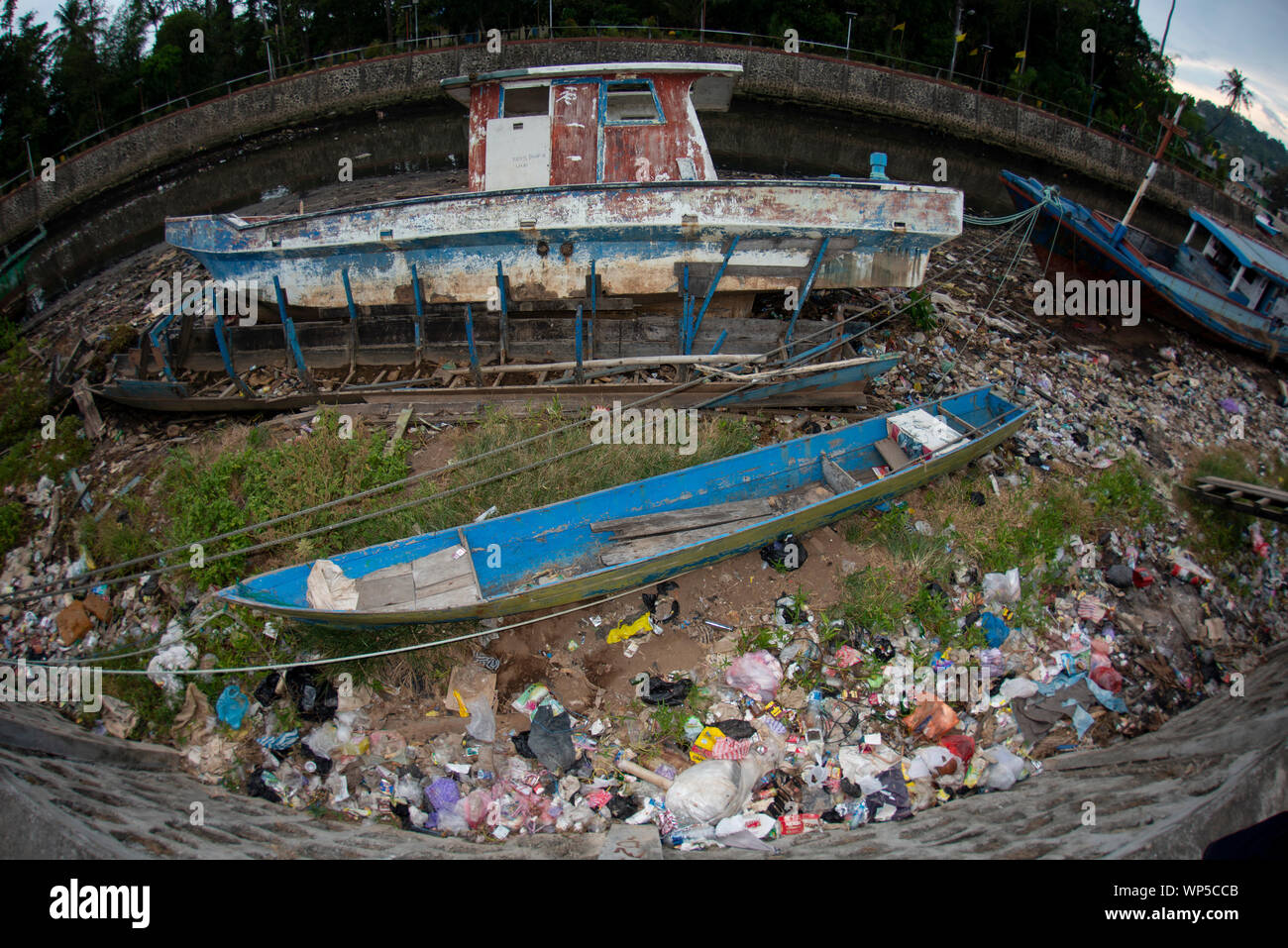 Barche fatiscenti sulla terra con la garbage dal fiume, Sorong, Papua occidentale, in Indonesia Foto Stock