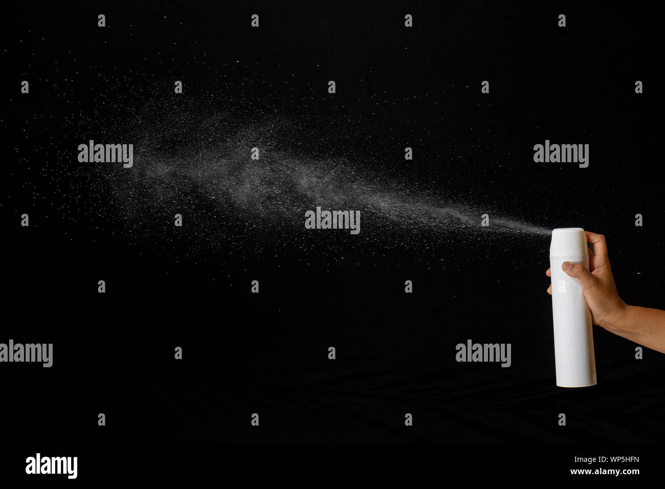 Spray, polverizzato il fluido in uscita da un contenitore sopportato da una mano umana Foto Stock